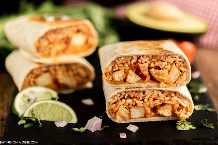 Close up image of chicken and rice burritos stacked. 