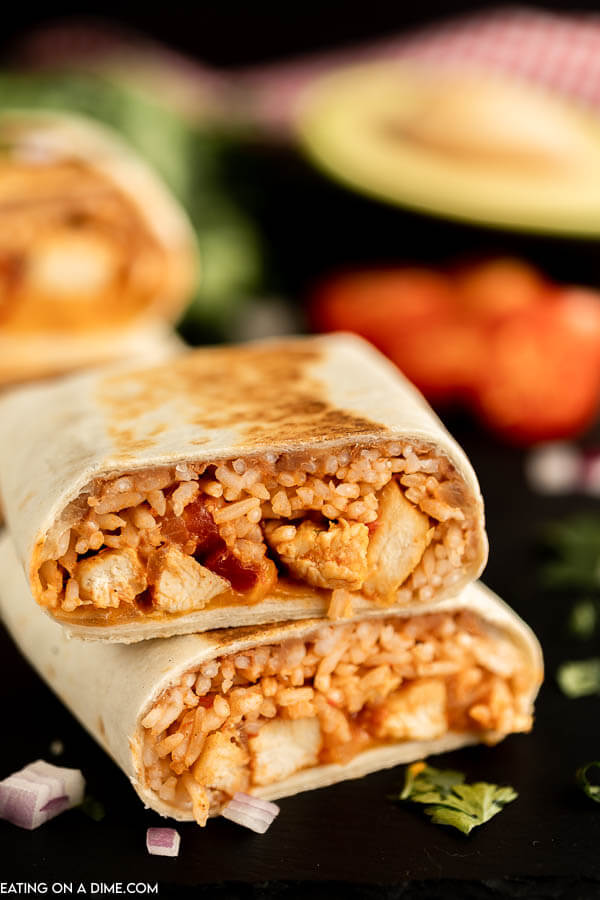 Close up image of chicken and rice burritos stacked. 