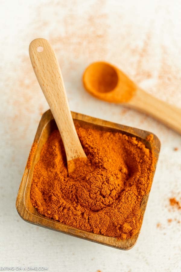 Close up image of a brown saucer with ground cayenne pepper with 2 teaspoons 