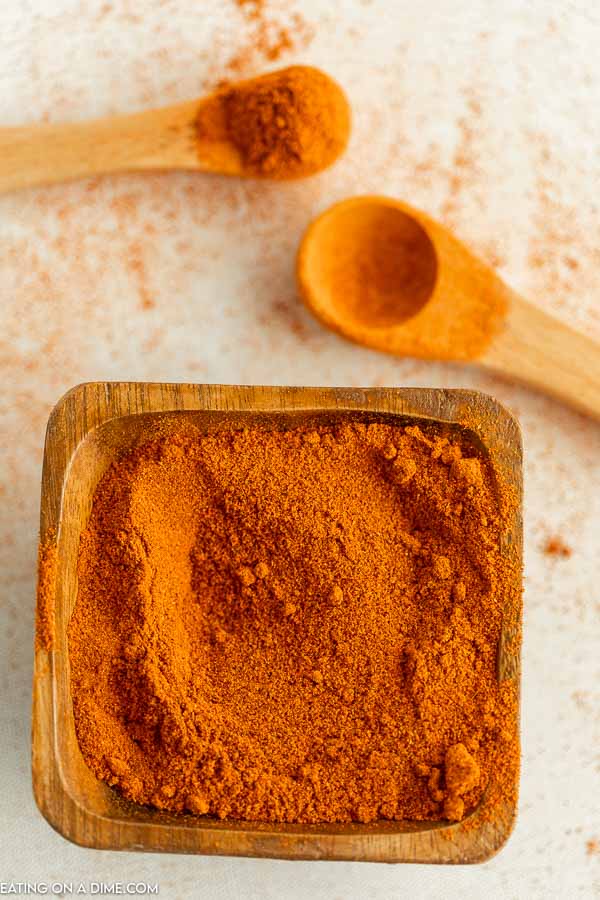 Close up image of a brown saucer with ground cayenne pepper with 2 teaspoons 
