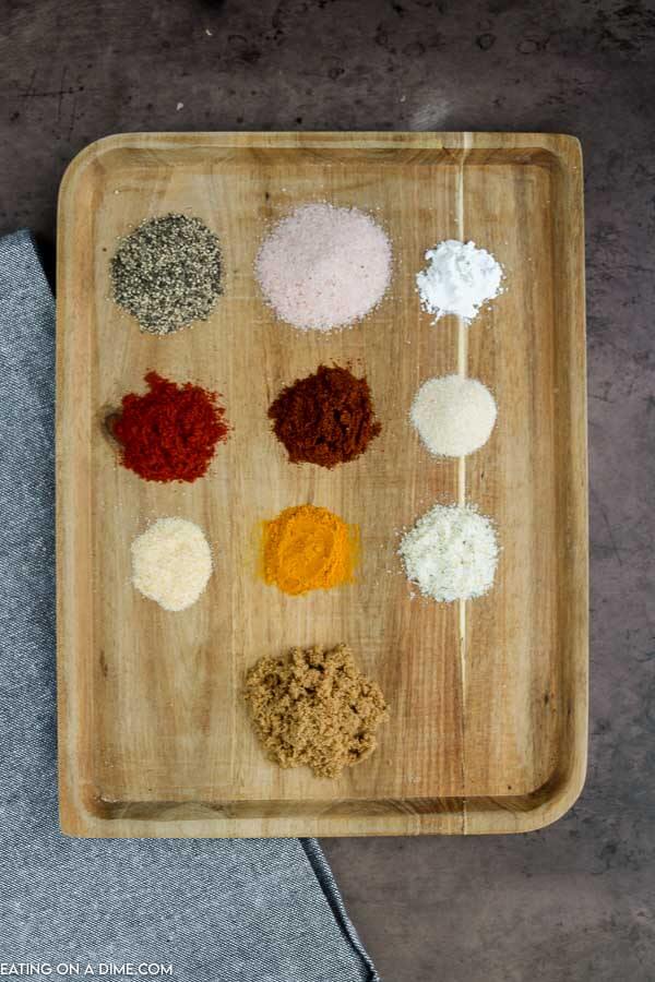 Seasoning blends needed for recipe on cutting board. 