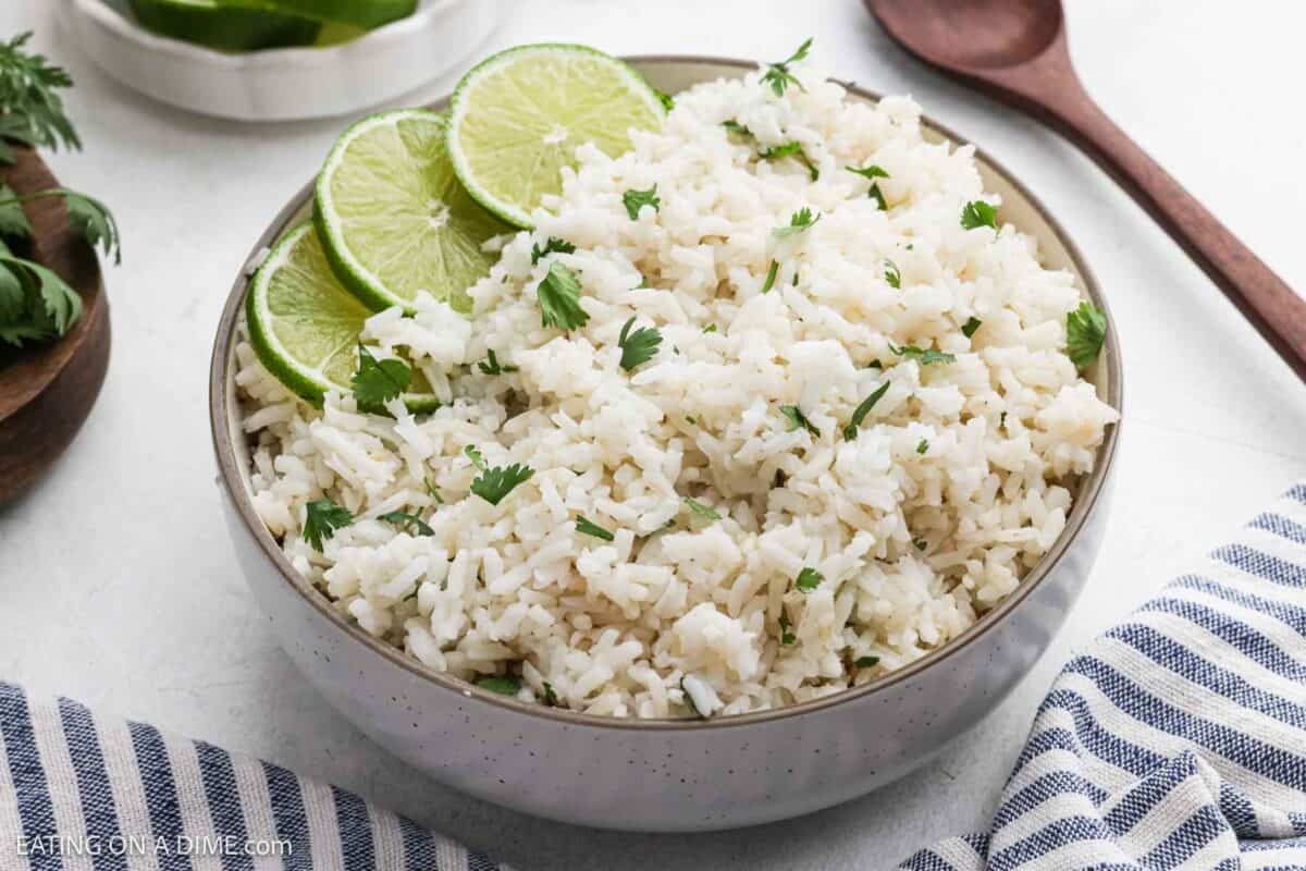 Cilantro lime rice in a bowl and garnished with slices of fresh lime.