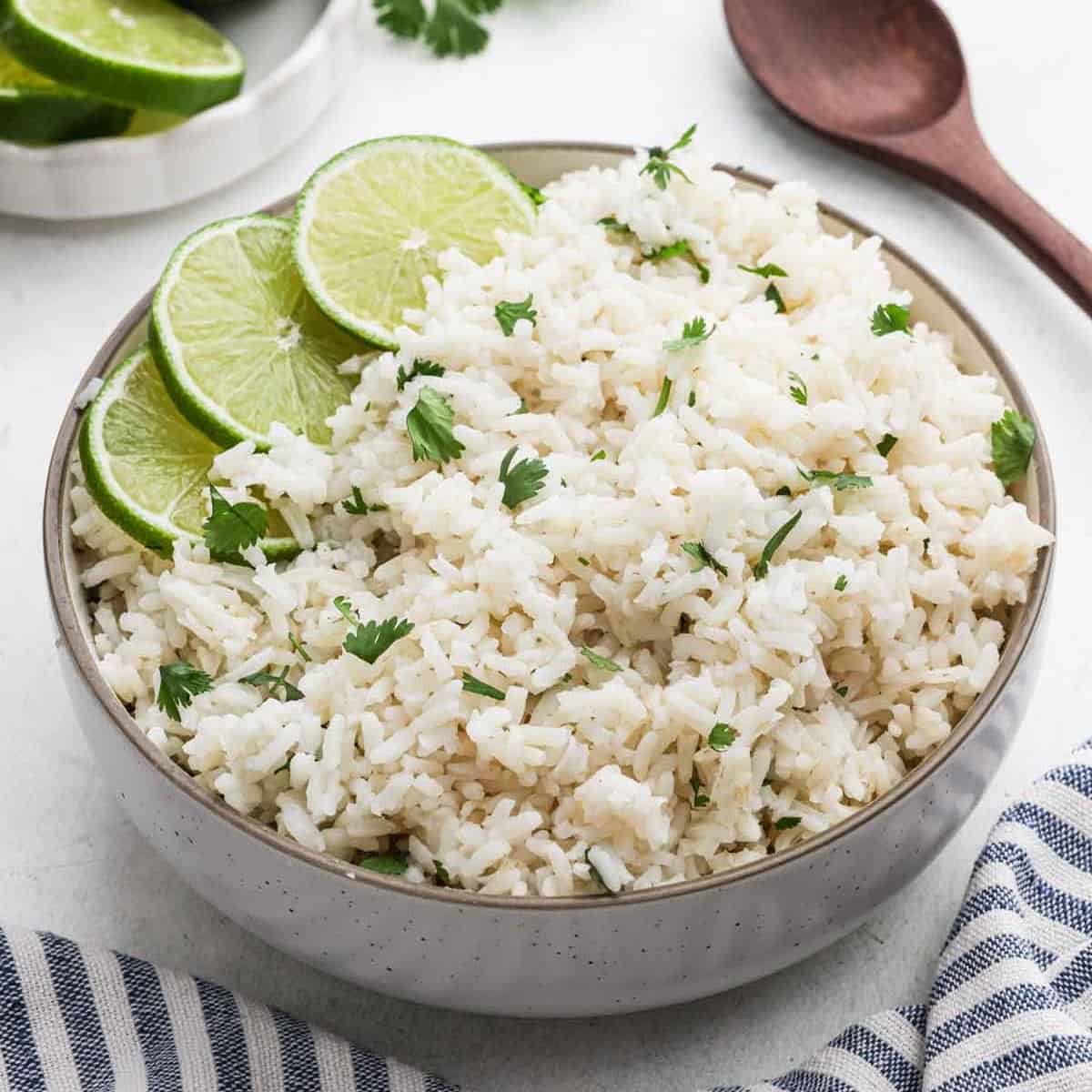 Cilantro lime rice in a bowl garnished with slices of fresh lime.