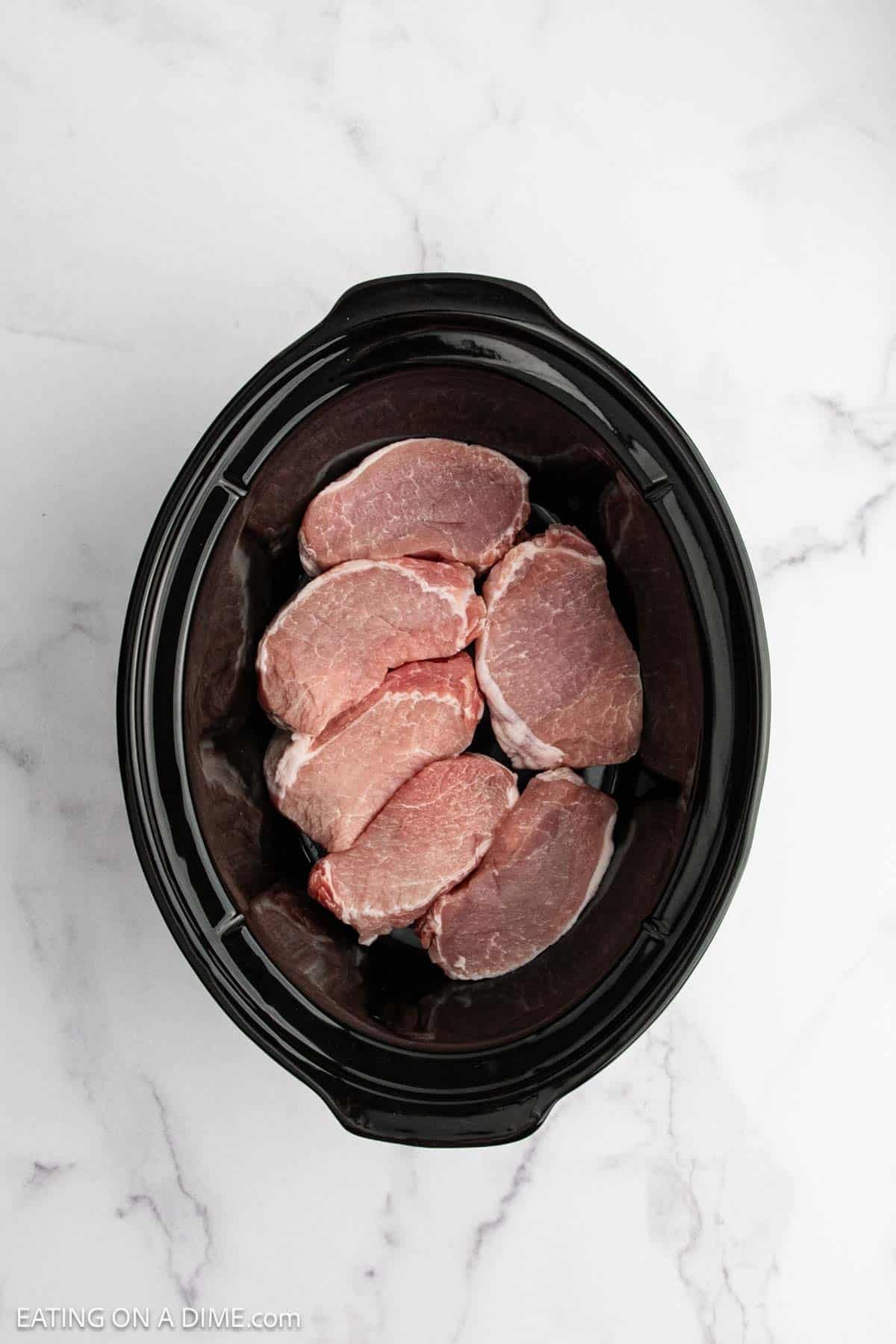 Pork chops placed in the slow cooker