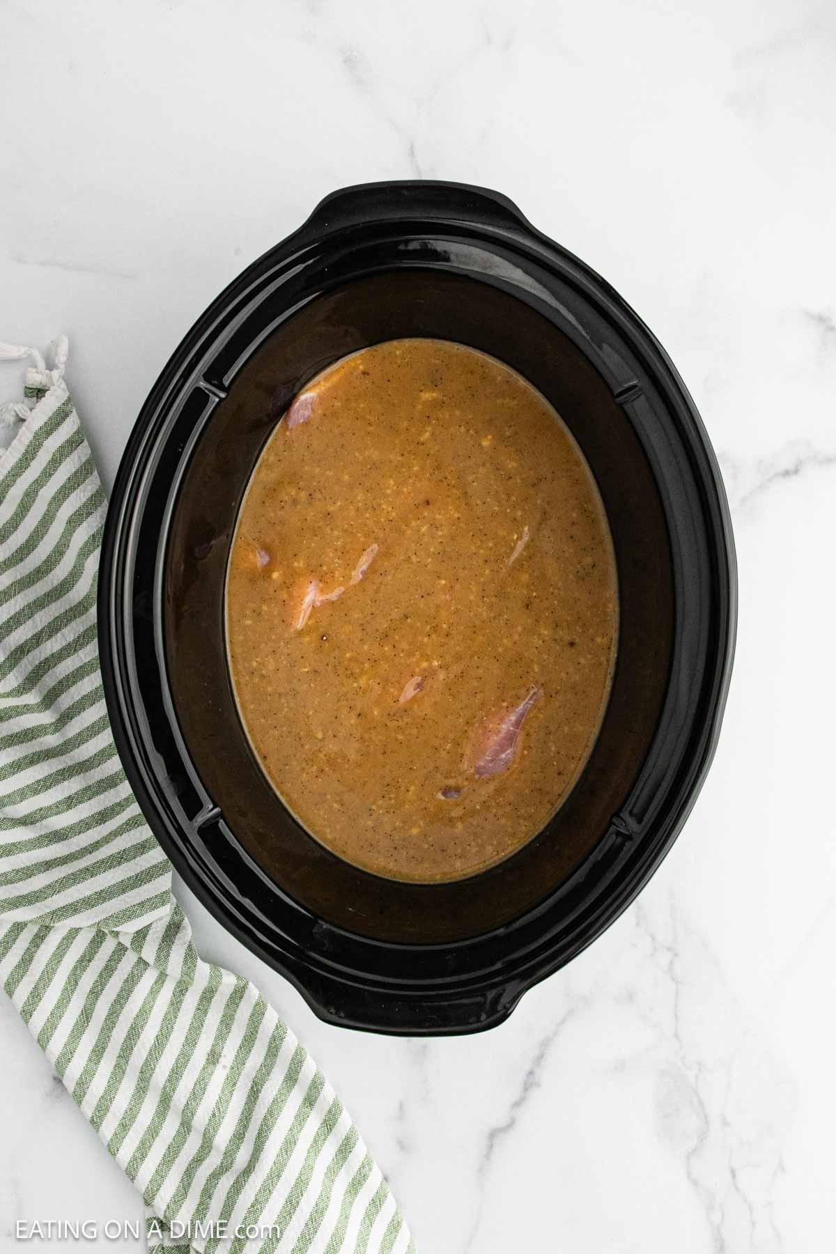 Gravy poured over the pork chops in the slow cooker