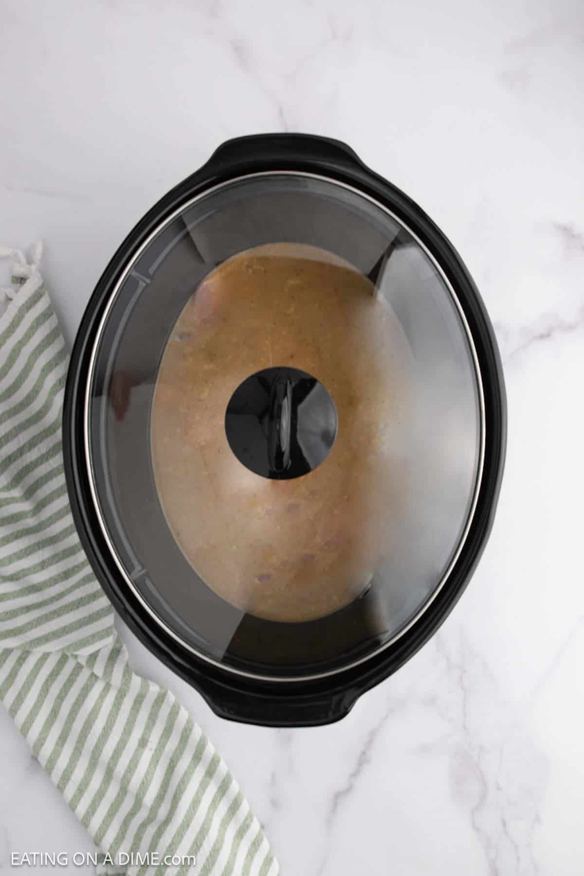 Pork chops in the slow cooker with the lid on top
