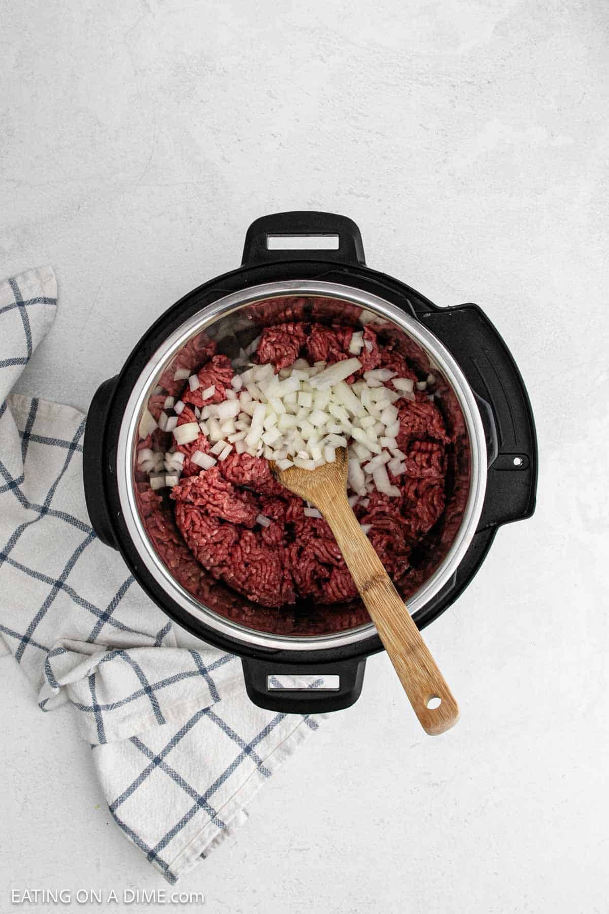 Ground beef and diced onions in the instant pot.