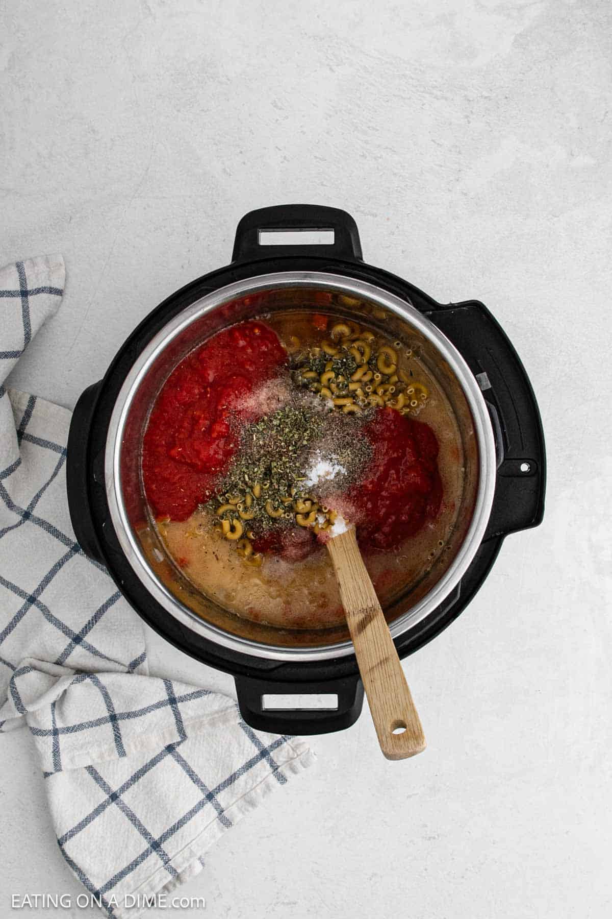 Broth, spices, crushed tomatoes and macaroni noodles in the instant pot.
