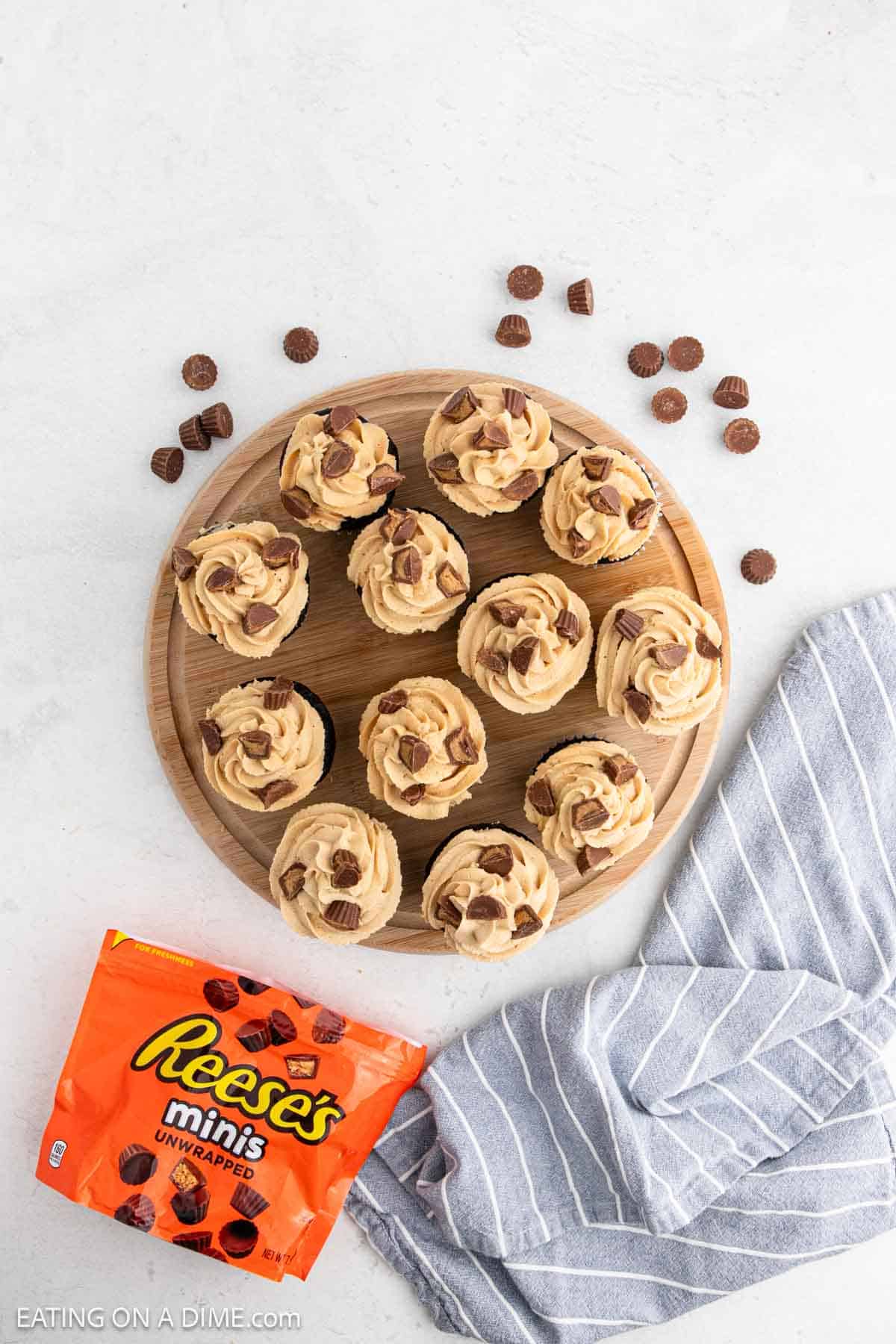 Reese's Cupcakes on a wooden tray topped with mini Reese's 