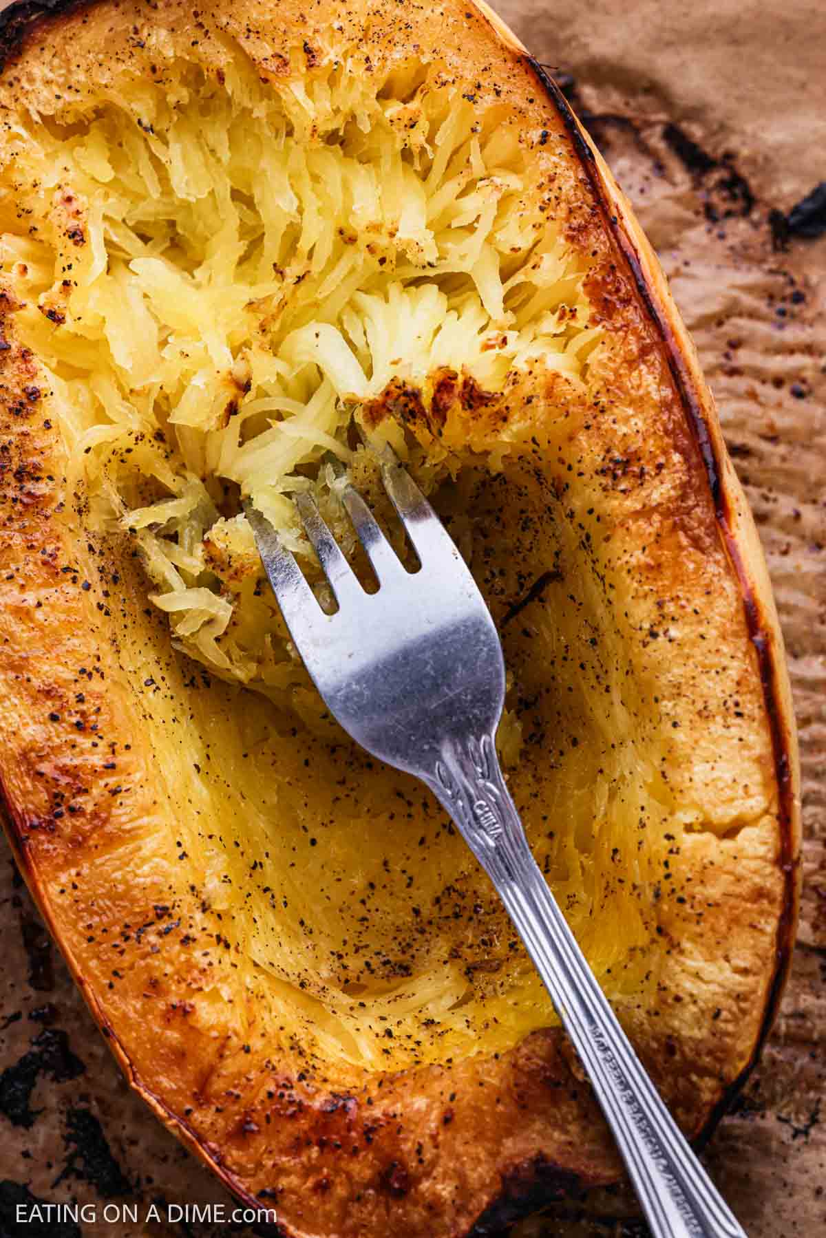 Close up of squash shredded into strands with a fork.