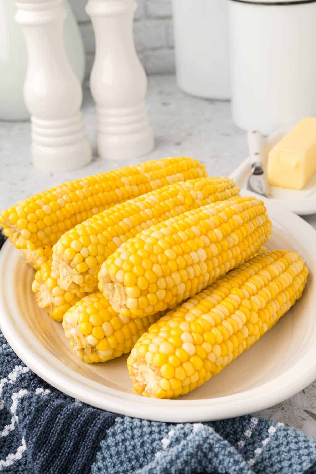Corn on the cob stacked on a white platter