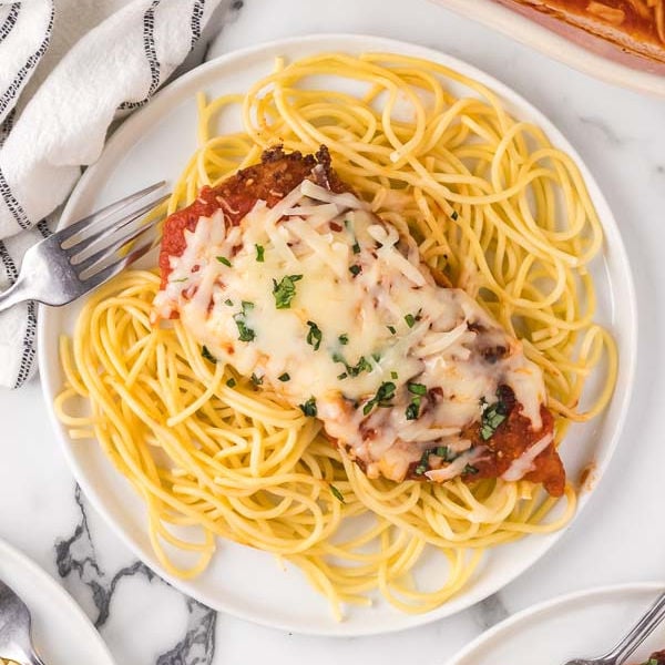 Chicken Parmesan on a plate with pasta. 