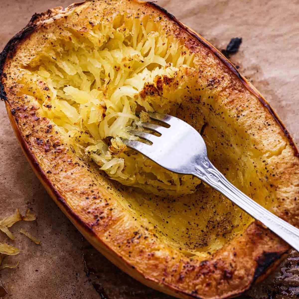 Roasted Spaghetti Squash with a fork shredding the squash into strands.