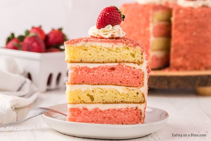 A slice of Strawberry Crunch Cake on a white plate