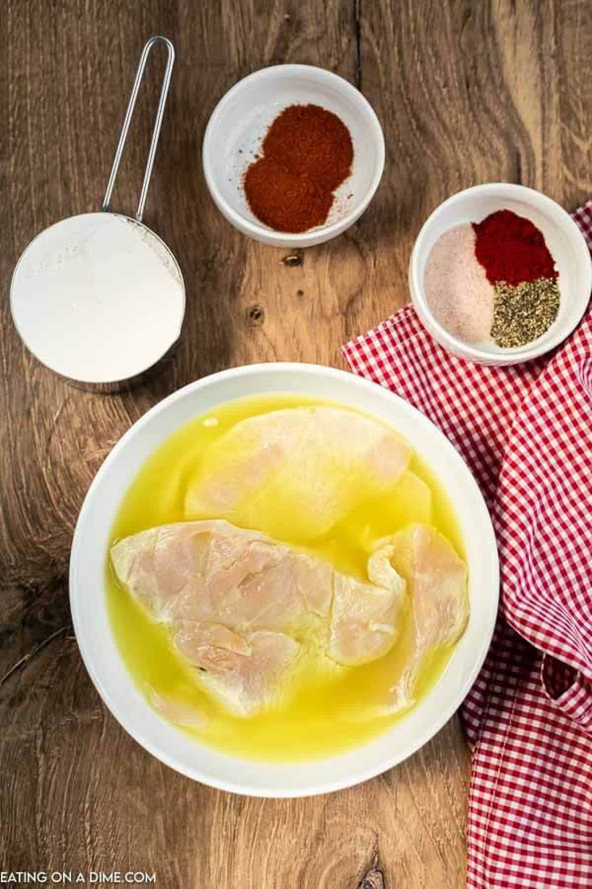 Chicken in bowl with milk and egg.
