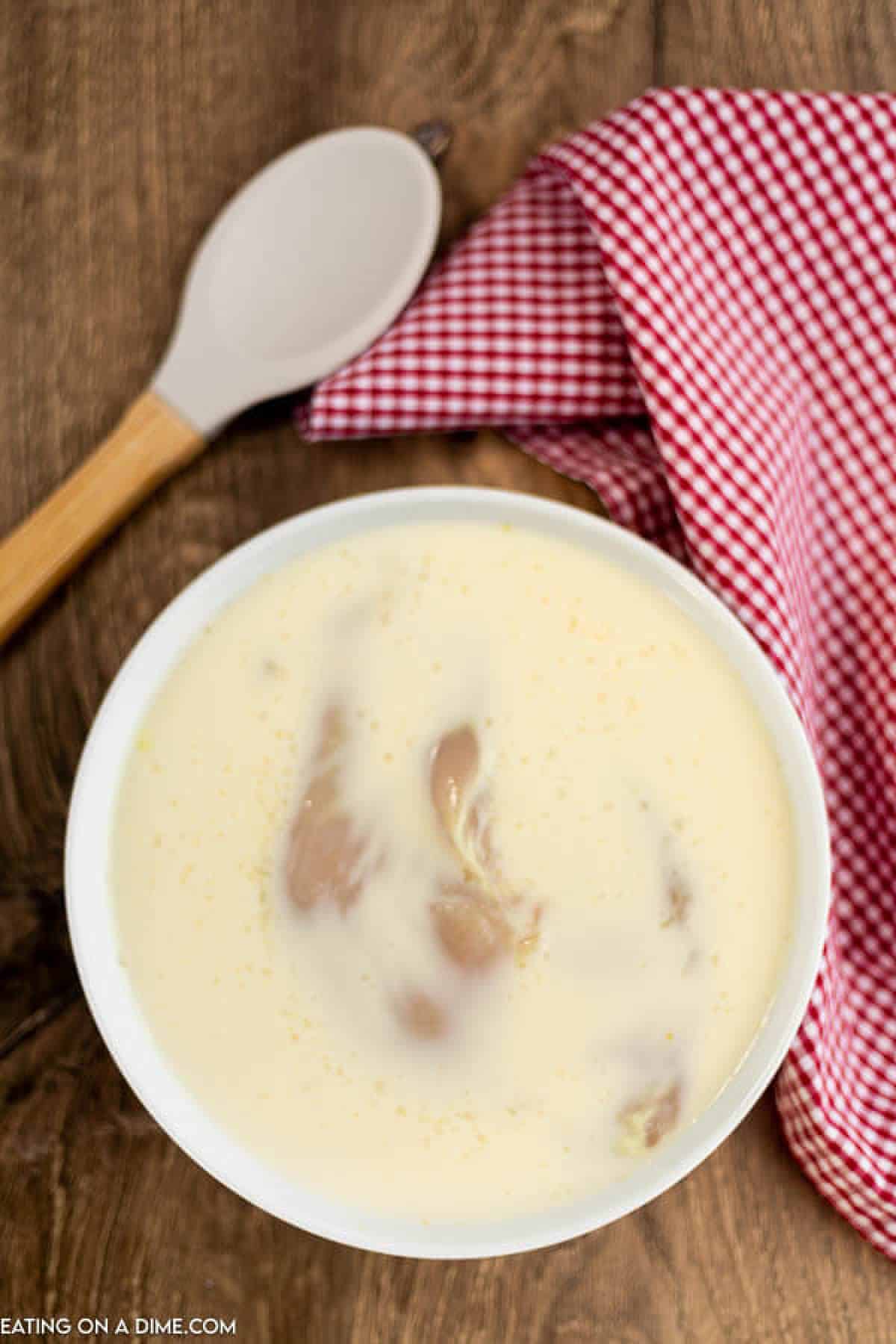 Chicken in bowl with pickle mixture. 