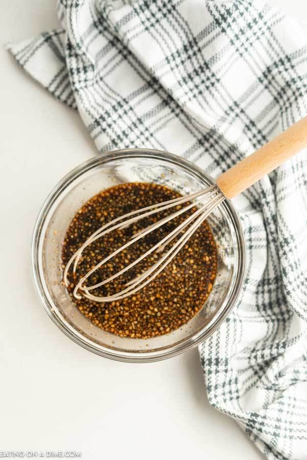 Teriyaki Sauce being mixed in a glass bowl with a whisk. 