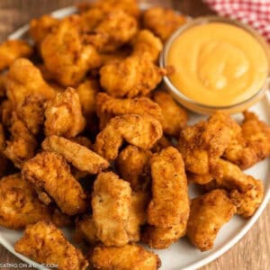 Chick-fil-A spicy nuggets on a white plate with dipping sauce.