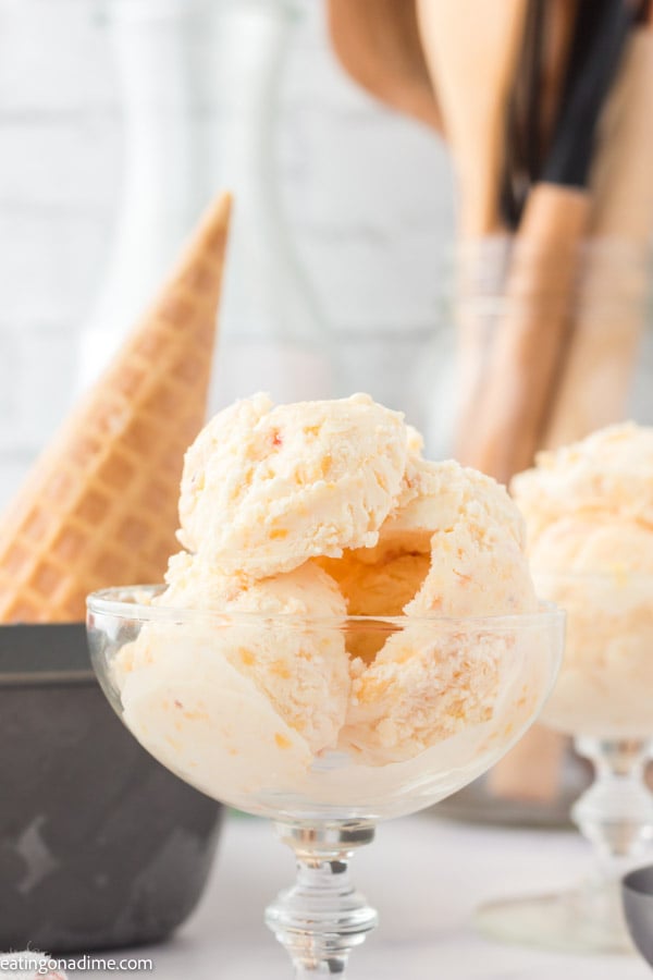 A close up image of peach ice cream in a serving dish. 