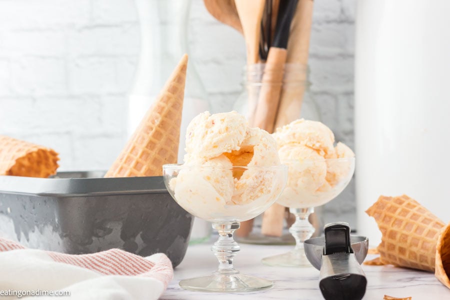 A close up image of peach ice cream in a serving dish. 