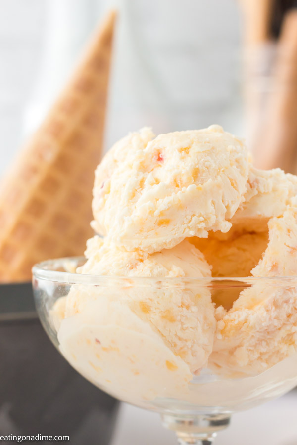 A close up image of peach ice cream in a serving dish. 