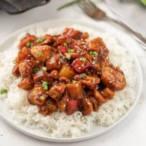 Pineapple chicken and rice on a plate.