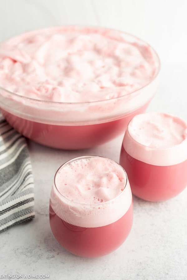 Close up image raspberry sherbet in two glasses and in a punch bowl. 