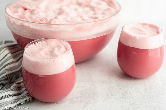 Close up image raspberry sherbet in two glasses and in a punch bowl. 