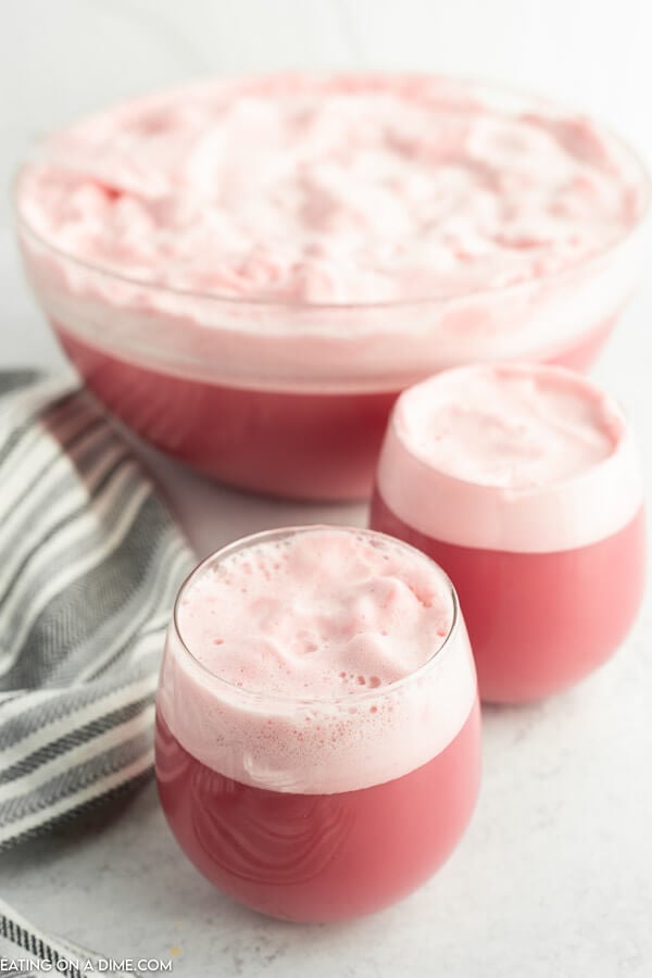 Close up image raspberry sherbet in two glasses and in a punch bowl. 