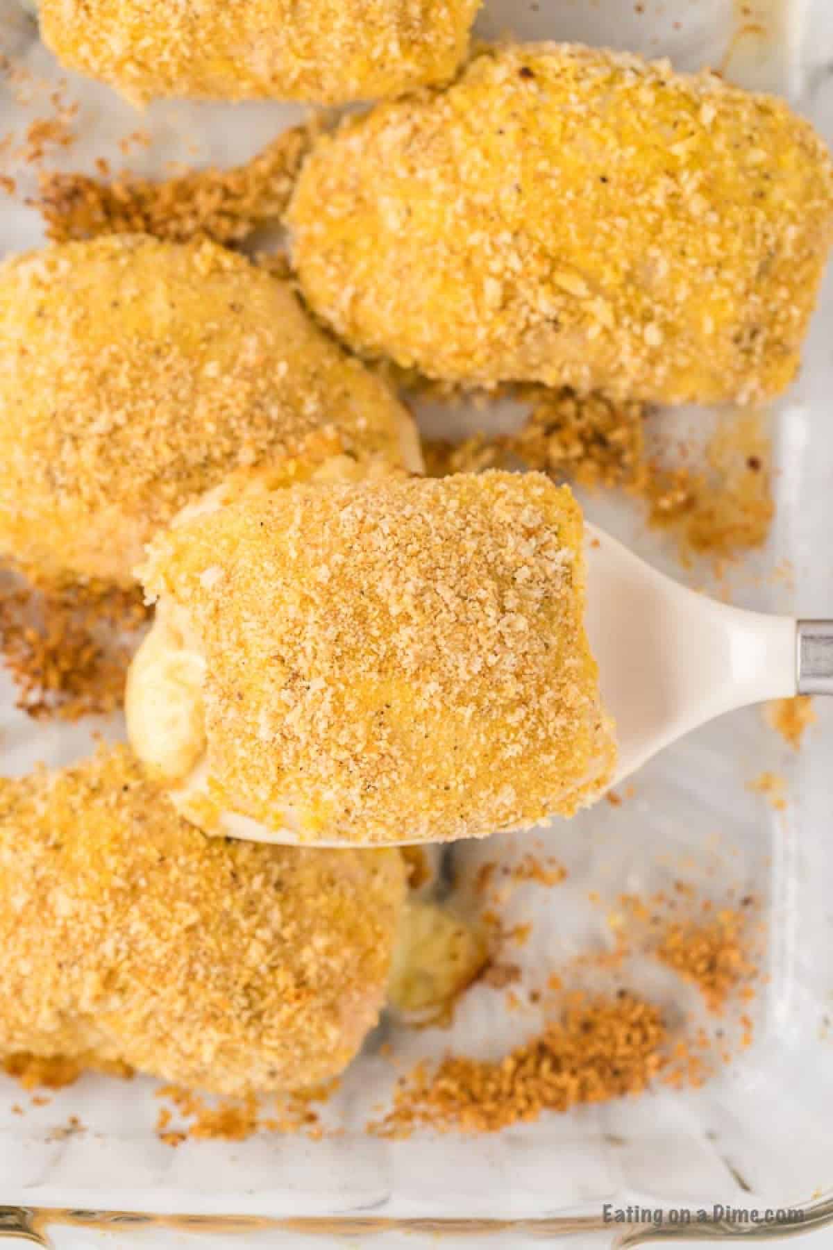 Placing the coated rolled chicken breasts on a baking sheet.