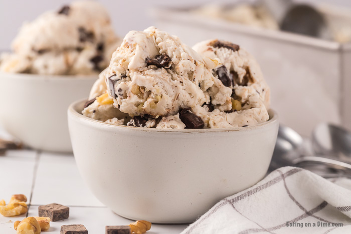 Close up image of chunky monkey ice cream in a container with an ice cream scoop. 