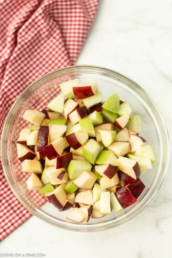 Close up image of chopped apples in a clear bowl.