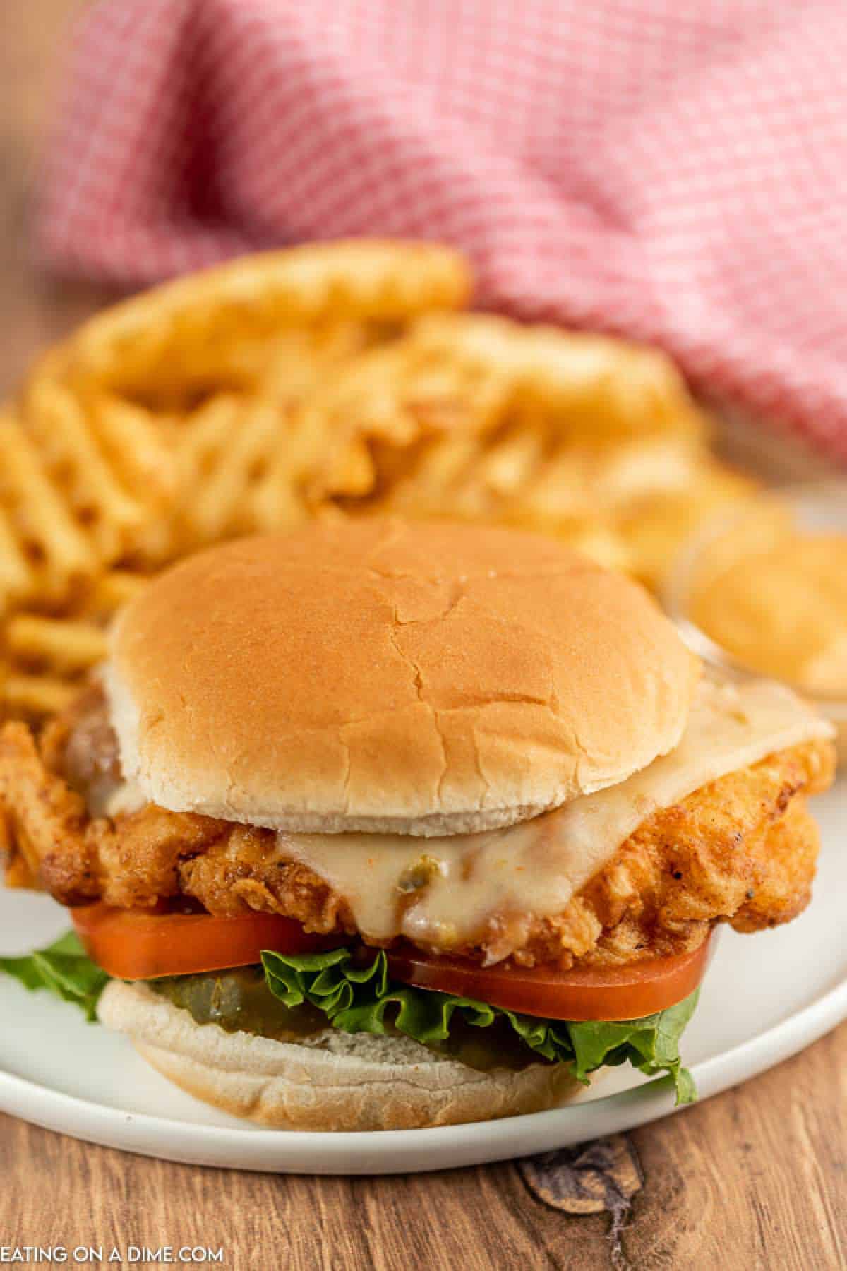 Close up image of Spicy Chicken Deluxe Sandwich with a side of fries.