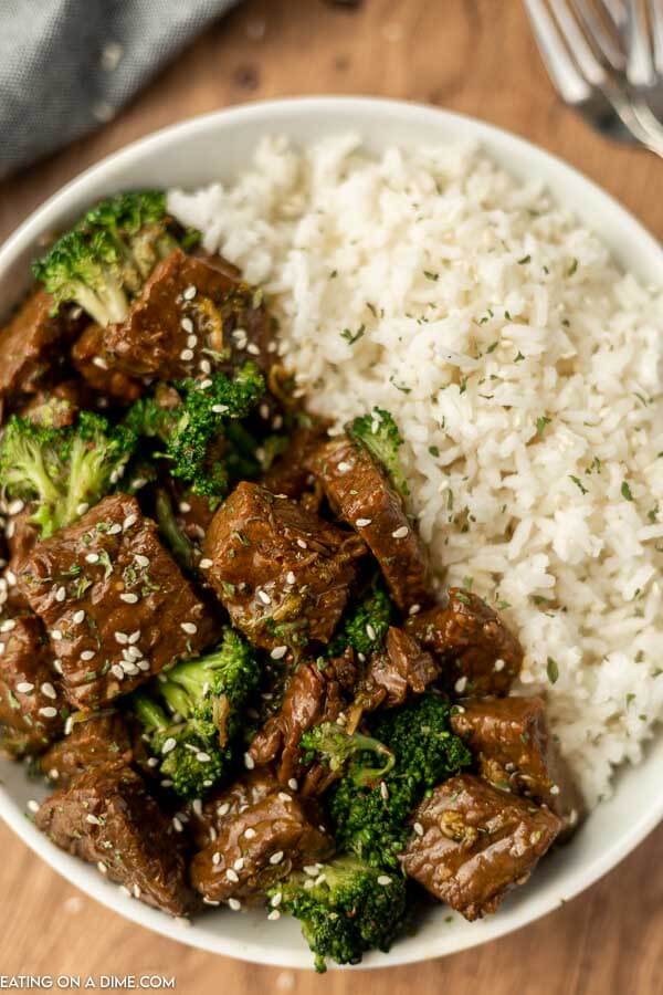 Close up image of beef and broccoli on a plate with a side of rice. 