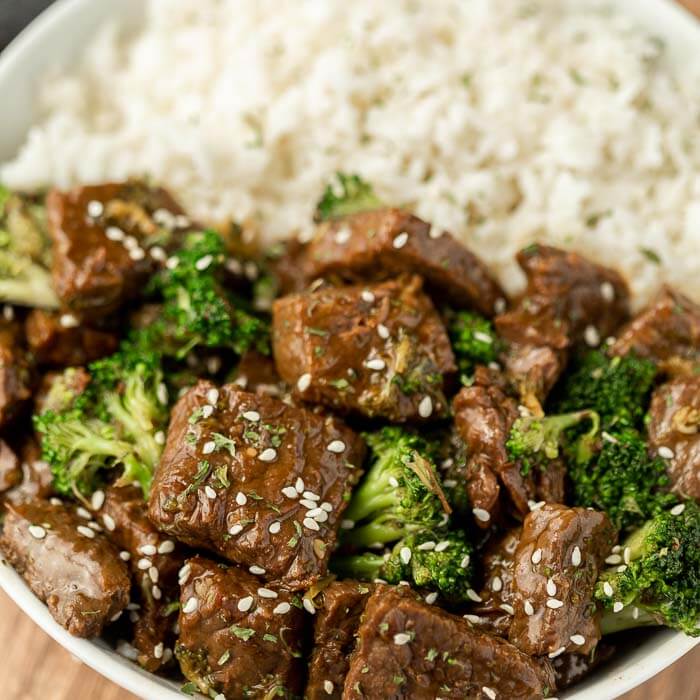 Close up image of beef and broccoli on a plate with a side of rice. 