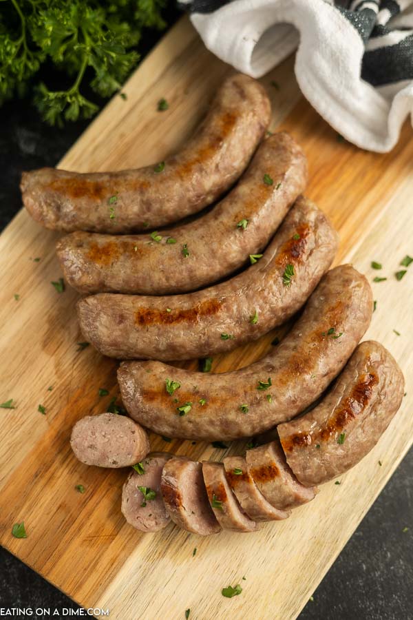 Close up image of cooked brats on a cutting board. 