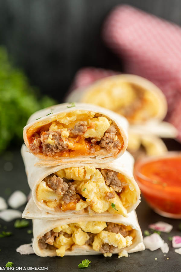 Close up image of breakfast burritos stacked. 