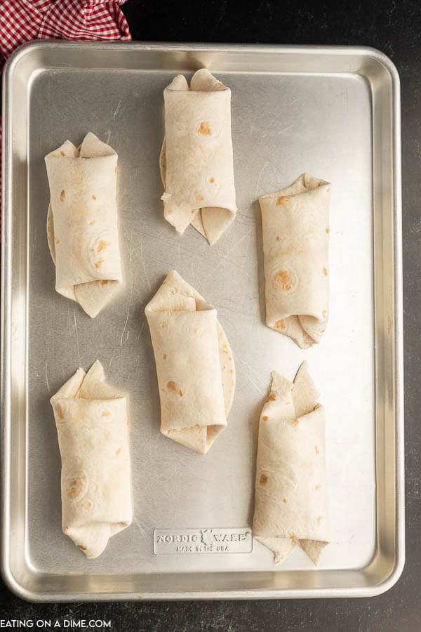 Breakfast Burritos prepared and placed on a baking sheet
