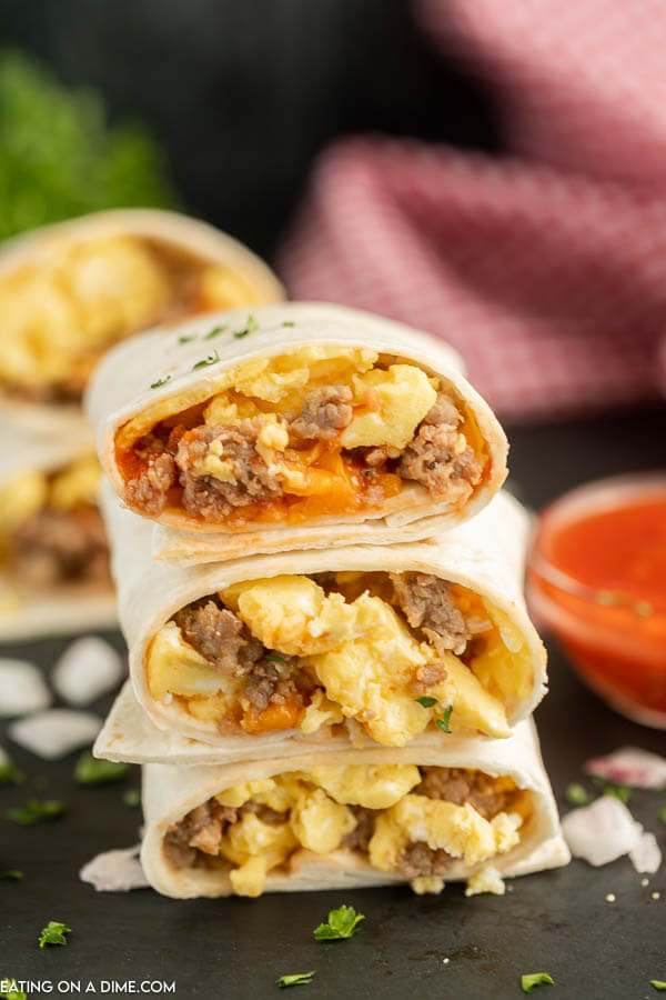 Close up image of breakfast burritos stacked. 