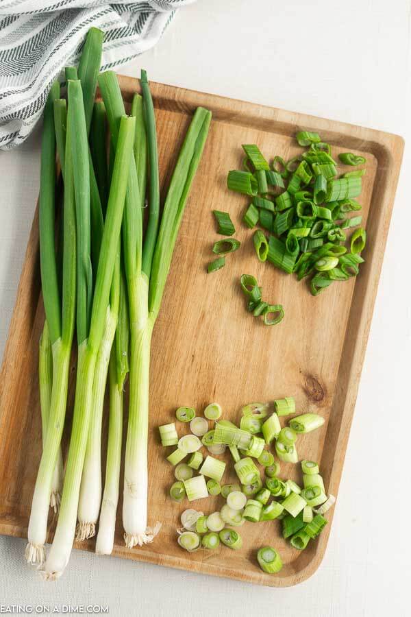 Close up image of green onion chopped on a cutting board. 