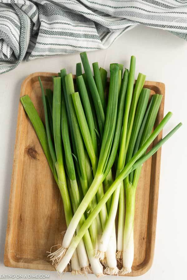 Close up image of green onion on a cutting board. 