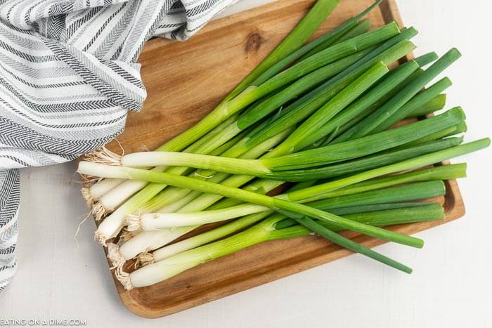 Close up image of green onion on a cutting board. 