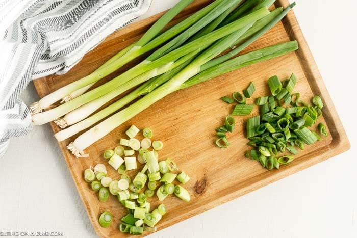 Close up image of green onion chopped on a cutting board