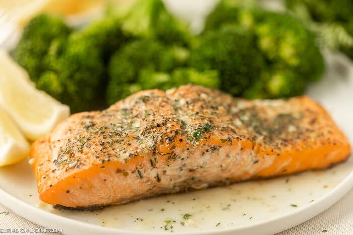 Olive garden herb grilled salmon on a plate with broccoli. 