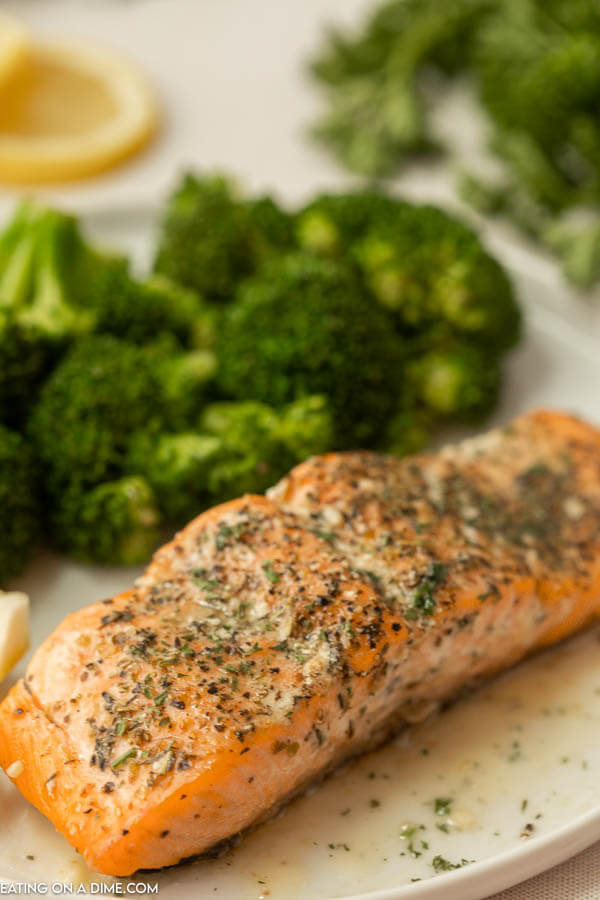 Olive garden herb grilled salmon on a plate with broccoli. 