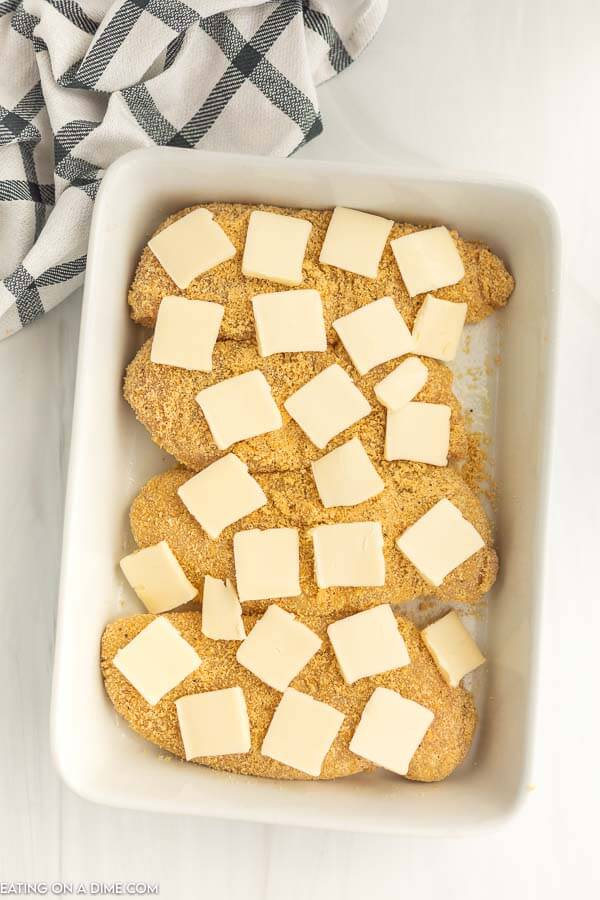 Ritz Cracker Chicken on a baking dish slices of butter on top. 