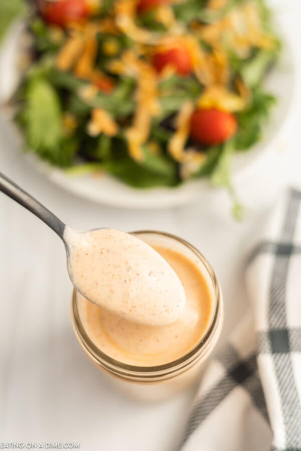 Close up image of Southwest Salad Dressing in a mason jar with a serving on a spoon. 