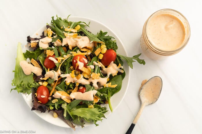 Close up image of Southwest Salad Dressing in a jar and topped on a salad. 