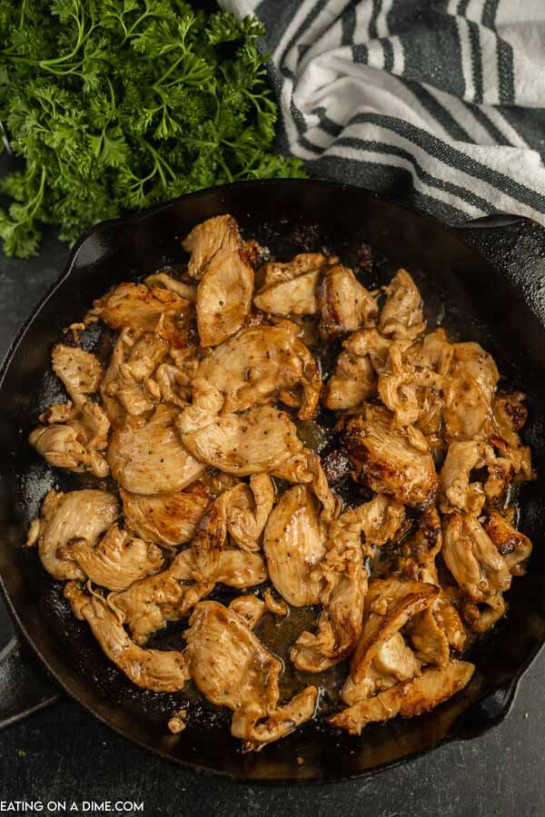 Cooked chicken with sauce in a cast iron skillet. 