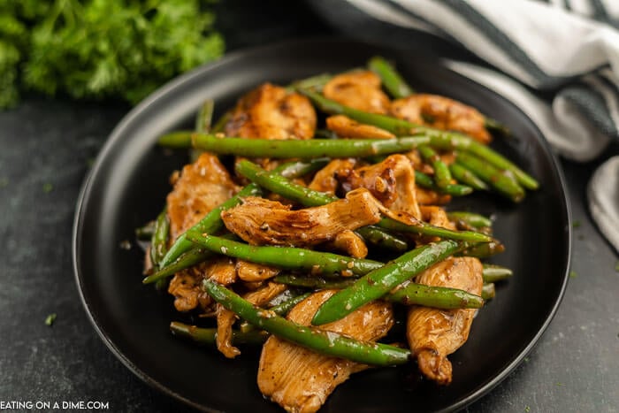 String Bean Chicken on a black plate. 